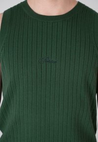 Green knitted tank top with ribbed texture, featuring a crew neckline and subtle embroidered branding on the front.