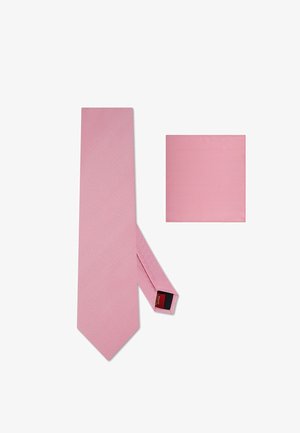 Gładki jasnoróżowy krawat i pasująca poszetka ułożone płasko na białym tle, ukazujące fakturę tkaniny.