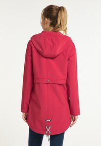 Giacca antipioggia rossa con cappuccio in tessuto impermeabile, dotata di coulisse in vita e sull'orlo, con dettagli in metallo argentato.