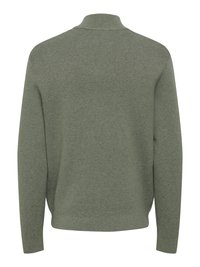 Pull vert en maille avec col haut, manches longues et coupe décontractée. Tissu texturé avec col et poignets côtelés.