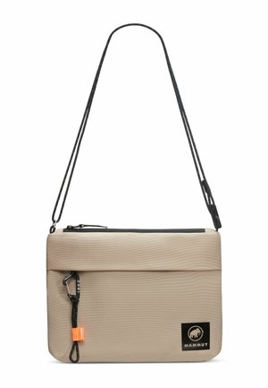 Beige shoulder bag with textured fabric, black zipper, and adjustable strap. Features a logo patch and a small orange tag for detail.