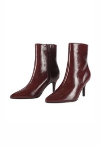 Stivaletti in pelle bordeaux con punta affusolata, silhouette elegante e zip laterale. Il tacco alto aggiunge altezza ed eleganza.