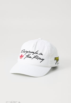 White baseball cap made of cotton with a curved brim. Features black embroidered text and a colorful leopard graphic on the side.