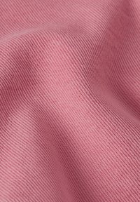 Tejido texturizado en suave rosa, con una delicada trama diagonal. La superficie es lisa con sutiles variaciones en el tono.