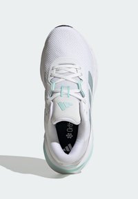 Chaussure de sport blanche et vert menthe avec une tige en mesh, des lacets et un col rembourré vue de dessus sur un fond clair.