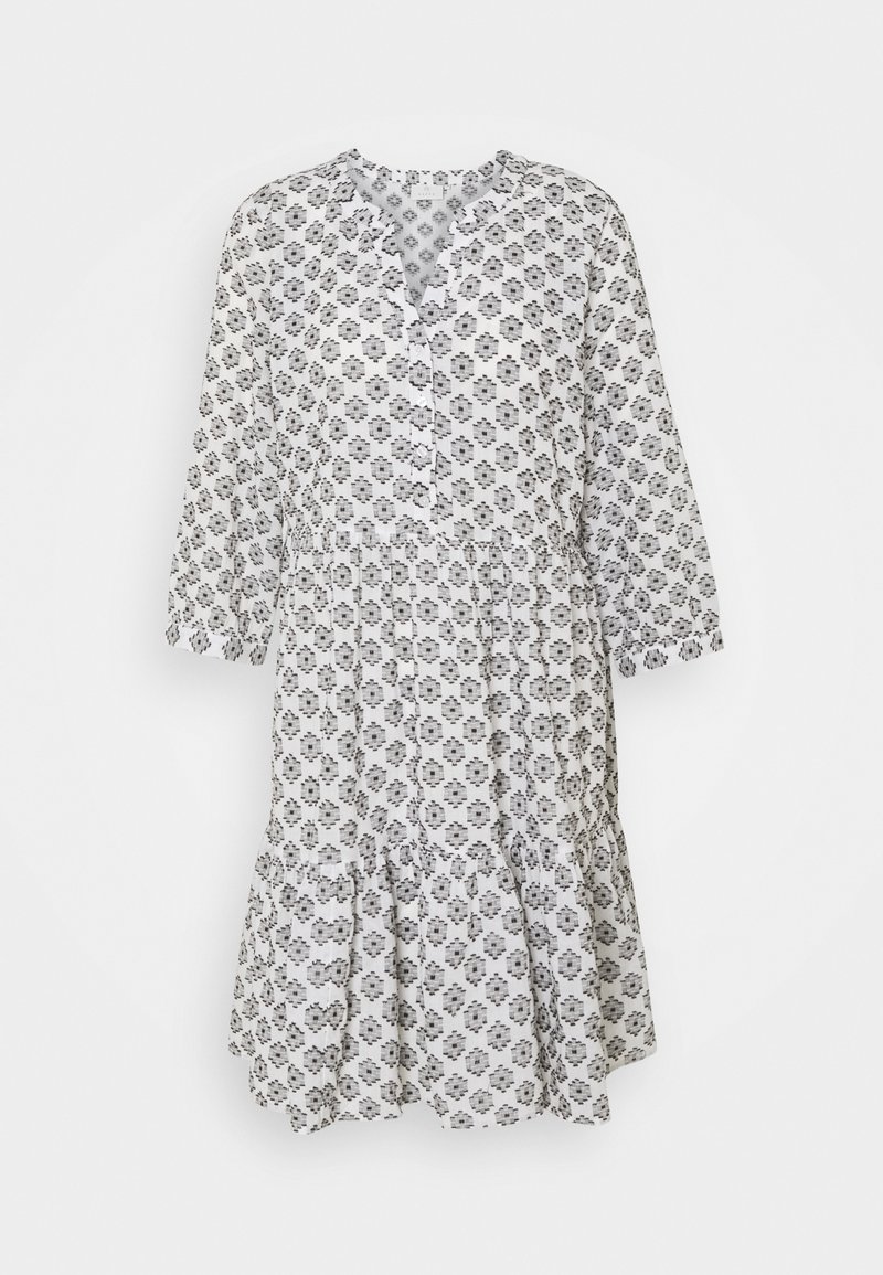 Valkoisessa kukkakuosisessa mekossa on mustia yksityiskohtia, V-pääntie, kolmen neljänneksen hihat ja röyhelöhelmastus.