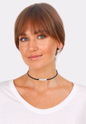 Black choker necklace featuring a thin, rectangular white pendant. The cord is sleek, with a smooth texture, and sits closely around the neck.