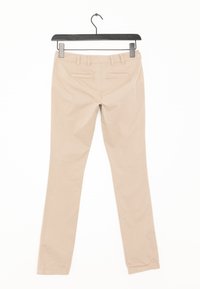 Beige, schmal geschnittene Hose mit flachem Bund, Gürtelschlaufen, zwei Gesäßtaschen und glatter Textur. Hängt an einem schwarzen Plastikclip.