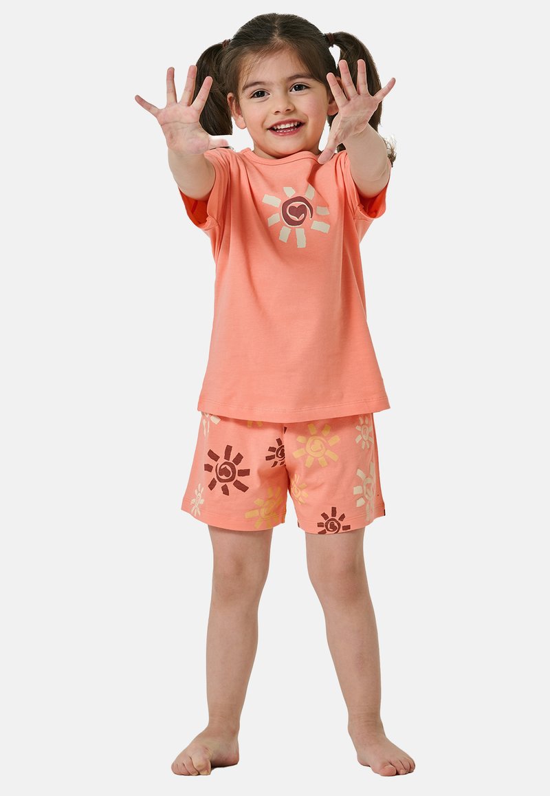 Brzoskwiniowy bawełniany t-shirt z grafiką słońca oraz pasujące szorty z wzorem słońca w kolorach brązowym i żółtym. Krótkie rękawy, luźny krój.