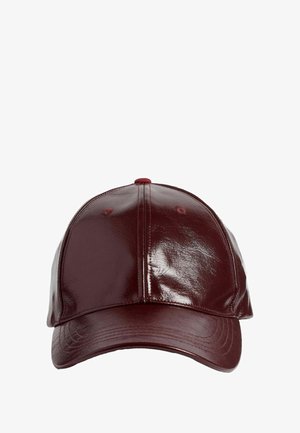 Burgundia kork, mis on valmistatud läikivast, tekstuuriga materjalist. Omab ümarat pead, kumerat ääre ja õmbluse detaile peal ja külgedel.