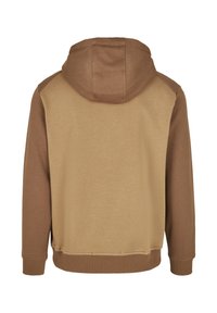 Ruda gobtuva džemperis su dviem atspalviais; viršuje šviesesnės smėlio spalvos audinys, rankovėse ir apačioje tamsesnė ruda spalva. Minkšta tekstūra.