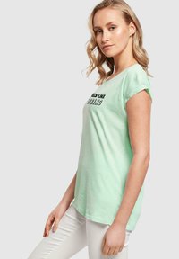 Merchcode SPRING FEELS LIKE EXTENDED SHOULDER - T-shirts med print - neo mint