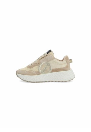Zapatilla beige y crema con suela blanca gruesa y texturizada, parte superior de ante y malla, puntera redonda, con cordones y detalle de logo circular en el lateral.