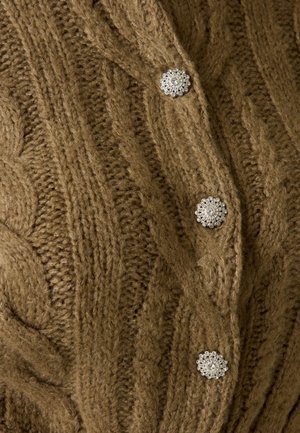 Cardigan marron en tricot avec des motifs torsadés et trois boutons décoratifs argentés en forme de fleurs alignés verticalement.