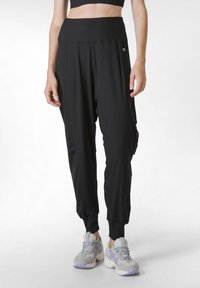 Zwarte geribbelde joggers met een hoge tailleband, zijzakken, taps toelopende boorden en een klein logo op de linkerheup.