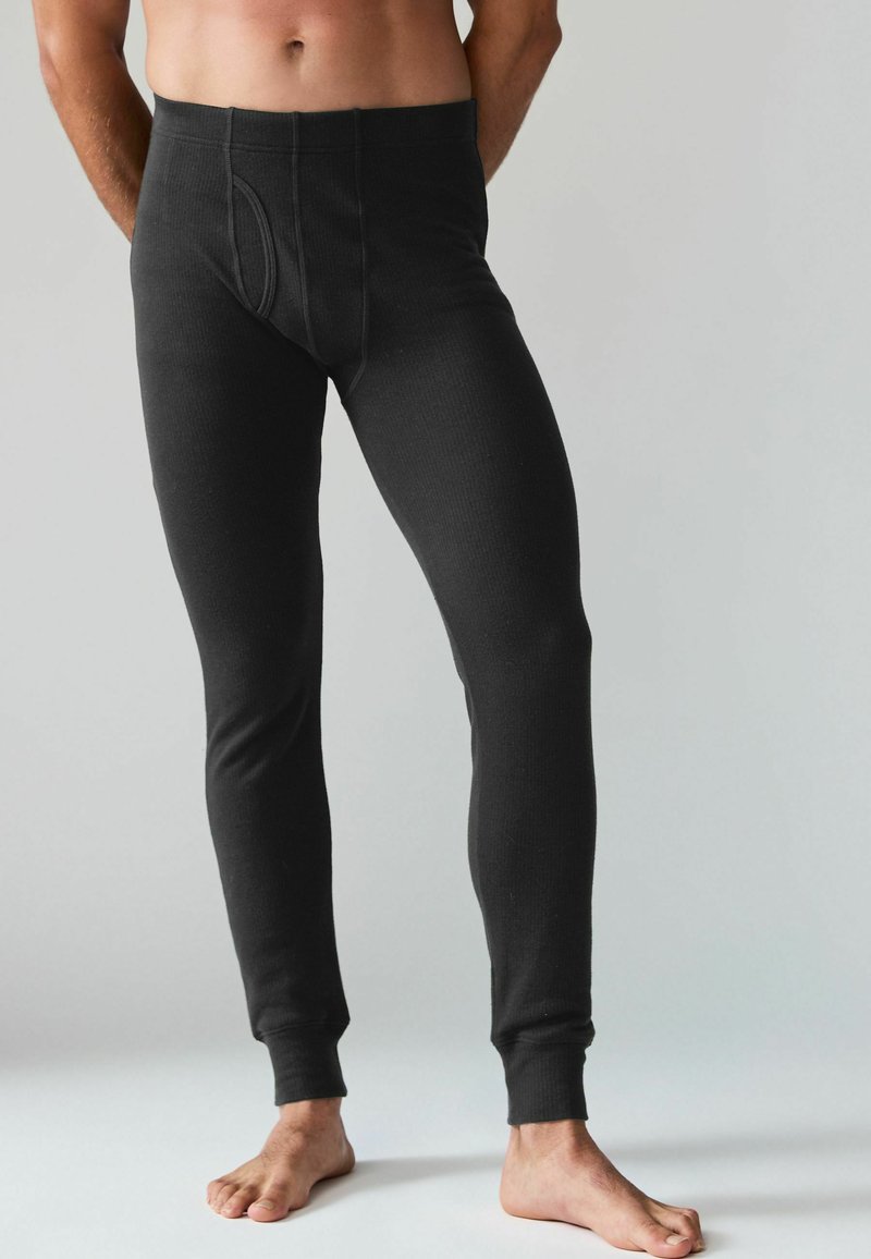 Schwarze lange Unterwäsche für Männer aus geripptem Stoff, mit passgenauem Design, Knöchelriemen und einer Öffnung vorne, ohne weitere Details.