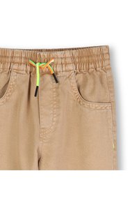 Παντελόνι με κορδόνι σε καφέ απόχρωση με ελαστική μέση, που διαθέτει κορδόνια νέον πράσινου και πορτοκ αλί χρώματος, καθώς και πλαϊνές τσέπες με διακριτικές ραφές.