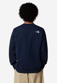 Felpa crewneck blu navy realizzata in tessuto misto cotone, con polsini e orlo a coste, e un piccolo logo bianco sulla parte superiore della schiena.