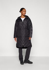Black quilted long coat with a hood, featuring a full-length zipper and horizontal stitching, worn over dark pants and black shoes.