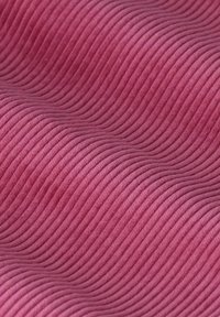 Getextureerde stof in een zachte roze tint, met horizontale golvenpatronen en een fluwelen afwerking, wat diepte en visuele interesse creëert.