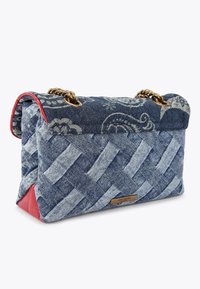 Borsa in denim con design intrecciato intricato in tonalità di blu chiaro e scuro. Presenta un accento rosso sul fondo e una tracolla in catena dorata. Motivo paisley notevole.