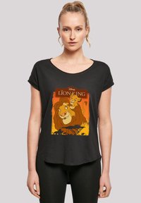 Svart t-skjorte med scoop-hals og en fargerik "Lion King" grafikk, som viser en løve og en løveunge med gradient oransje bakgrunn.