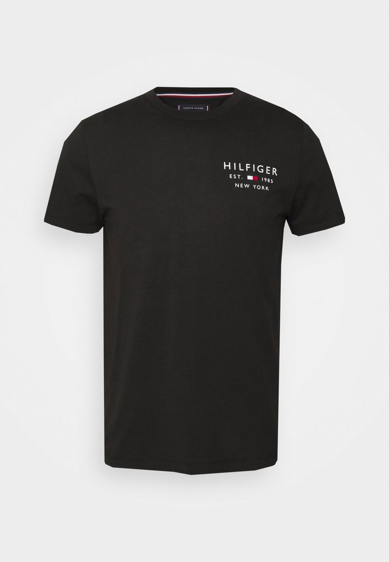 Czarny T-shirt z krótkim rękawem i okrągłym dekoltem z białym napisem "HILFIGER EST. 1985 NEW YORK" oraz małym czerwono-biało-niebieskim logo na klatce piersiowej.