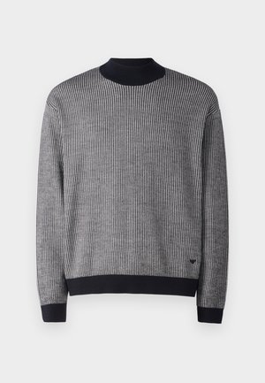 Maglione lavorato a maglia in bianco e nero con texture a costine, colletto rotondo e polsini e orlo a contrasto in nero. Presenta un piccolo logo sull'orlo.