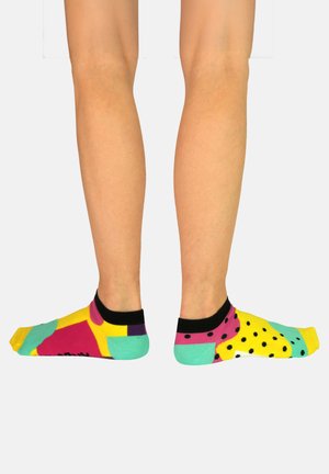 Calcetines de tripulación multicolores con patrones geométricos, colores llamativos como rosa, amarillo y turquesa, con acentos negros y un diseño de talón en contraste.