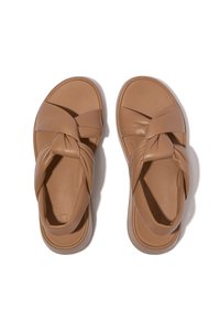 Bruine leren sandalen met een gedraaide bandontwerp, open teen, platte zool en een gladde textuur. Minimalistische stijl zonder versieringen.