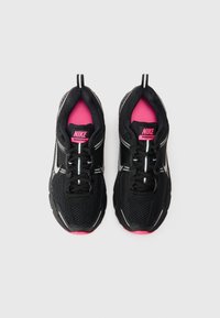 Crne Nike Vomero 5 tenisice imaju mrežasti gornji dio, ružičaste akcentne detalje, reflektirajuće elemente i čvrst gumeni potplat.