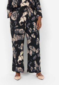 Black wide-leg pants featuring a watercolor-inspired abstract pattern in cream and gray tones with an elastic waistband and side pockets.