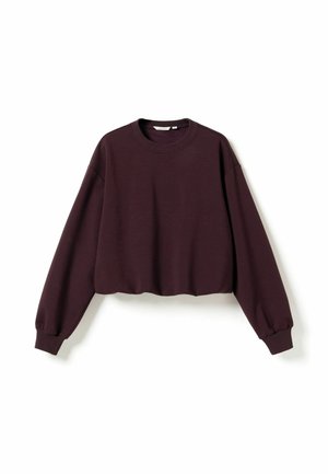 Langærmet cropped sweatshirt i mørk lilla med ribstrikkede manchetter og rund halsudskæring, lagt fladt på en hvid baggrund.