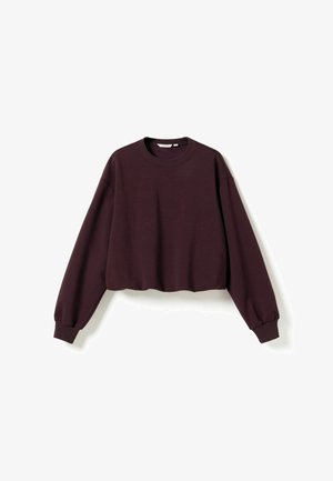 Langærmet cropped sweatshirt i mørk lilla med ribstrikkede manchetter og rund halsudskæring, lagt fladt på en hvid baggrund.