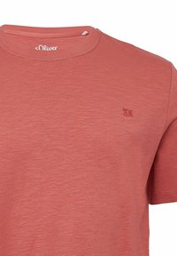 Baumwoll-T-Shirt in staubrosa Farbe mit rundem Ausschnitt. Verfügt über eine dezente Textur und ein kleines geprägtes Logo auf der Brust. Kurze Ärmel.