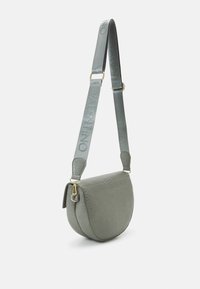 Borsa a tracolla in materiale grigio texturizzato, forma semicircolare, con tracolla con logo impresso e dettagli in metallo dorato.