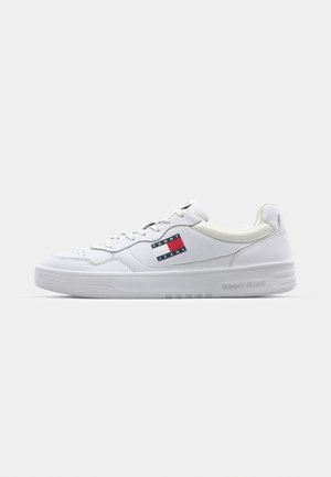 Hvit lær sneaker med snørelukking, rund tå og gummisåle. Har rød og blå Tommy Jeans-logo på siden. Minimalistisk design.