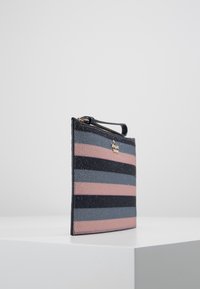 Striped clutch in black, pink, and blue, featuring a glittery texture, a zip closure, and a small handle for easy carrying.