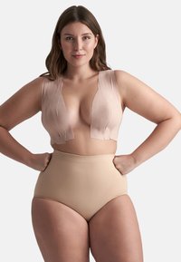 Nude bralette dengan pencelupan dalam, menampilkan kain bertekstur dan tali lebar, dipasangkan dengan celana dalam nude bertinggi tinggi dari bahan halus.