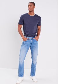 Laivaston Crew-neck t-paita, lyhyet hihat, yhdistetty vaaleansinisiin farkkuihin ja valkoisiin tennareihin. Rentoa tyyliä, puuvillamateriaalia, yksinkertainen muotoilu.