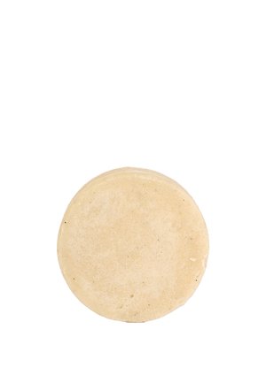 Barra di sapone rotonda, beige, con una consistenza liscia e solida e lievi irregolarità sulla superficie, caratterizzata da un lato superiore e inferiore piatti.