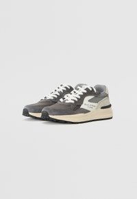 Sneakers in suede grigio con lacci bianchi, dettagli in rete e una suola intermedia crema. Presentano il marchio di fabbrica sul lato e una suola in gomma testurizzata.