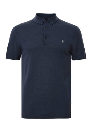 Tummansininen polo-paita, joka on valmistettu pehmeästä kankaasta. Paita sisältää kauluksen, kolme nappia ja pienen embleemin vasemmassa rinnassa. Lyhyet hihat.