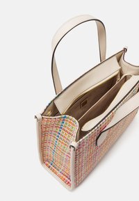 Torebka tote wykonana z wielokolorowego splotu z beżowymi skórzanymi uchwytami i wykończeniem, posiada beżową tekstylną podszewkę z zamykanymi na zamek kieszeniami oraz logo Guess.