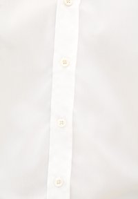 Witte blouse met een rechte kraag, zes witte knopen en een gladde, licht gestructureerde stof. Geen zichtbare patronen of accenten.