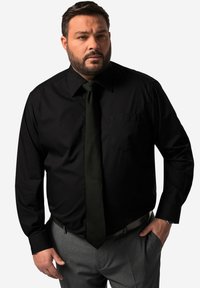 Zwarte lange mouwen shirt met een puntige kraag en een borstzak, gecombineerd met een donkergroene stropdas. Heeft een soepele, katoenachtige textuur.