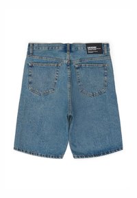 Shorts in denim di colore azzurro chiaro con taglio dritto, dotati di due tasche posteriori e un'etichetta sulla cintura. Tessuto testurizzato con una finitura sbiadita.