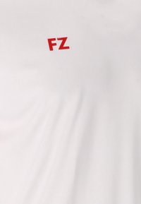 Valkoinen kangas, jossa ylhäällä keskellä on painettuna punaiset isoilla kirjaimilla "FZ".