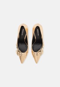 Paire de ballerines dorées à bout pointu avec des brides à boucle et des semelles intérieures noires marquées "Even&Odd" sur fond blanc.