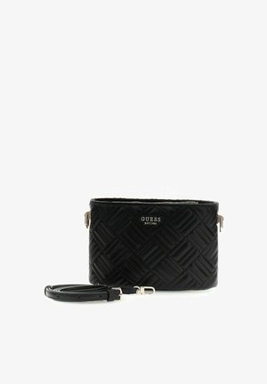 Sac bandoulière matelassé noir avec bandoulière détachable et logo GUESS argenté à l'avant, forme rectangulaire, design minimaliste.